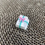 Artistic close-up of a handcrafted resin gift box keycap for ESC, showcasing its intricate bowknot and translucent finish.