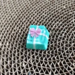 A unique angle of the handcrafted resin gift keycap, showcasing its delicate bowknot and miniature gift box design, ideal for a custom ESC.