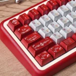 Elegant burgundy PBT keycap set, shown dynamically, highlights its premium texture, deep color, and ergonomic comfort for a sophisticated desktop.
