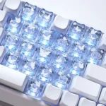 Glowing butterfly heart keycaps set made from translucent PC, showcasing their vibrant, whimsical designs and delicate glow from a playful, detailed angle.