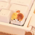 Handcrafted resin calico cat keycap shown from multiple angles, highlighting the intricately sculpted, adorable calico kitten design and whimsical charm.