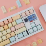 Close-up of adorable Candy Puppy PBT dye-sub keycaps set, showcasing pastel colors and whimsical candy designs from various angles, perfect for a sweet keyboard.