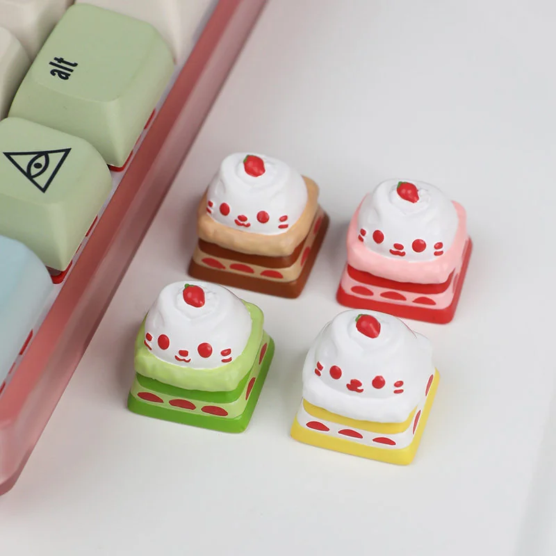 Handcrafted resin cat cake keycap, adorable and whimsical, with vibrant dessert details. Various angles reveal its playful charm.