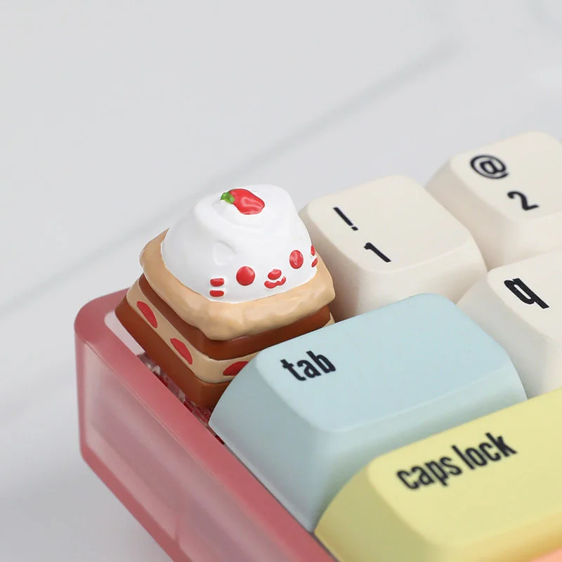 A delightful close-up of the handcrafted cat cake resin keycap, highlighting its adorable feline details and vibrant dessert hues from a charming angle.