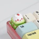 Exquisitely handcrafted adorable resin cat cake keycap showcasing its whimsical design and vibrant dessert details from a playful perspective.