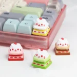 Showcases an exquisitely handcrafted resin cat cake keycap, featuring a whimsical cat atop a vibrant, adorable dessert. A playful keyboard accent.