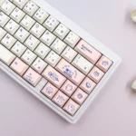 Playful cat keycaps set on a keyboard, featuring charming Japanese designs and durable PBT material, captured from multiple angles.