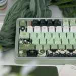 Close-up of an enchanting celestial artisan keycap, revealing its deep green cosmic hues, shimmering pearlescent night sky finish.