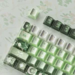 Close-up of the Celestial Keycap, showcasing its enchanting pearlescent night sky finish with deep green cosmic hues and shimmering celestial motifs.