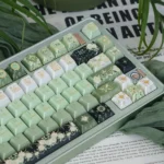 Close-up of an enchanting Night Astrology Cherry Keycap Set, showcasing its deep green cosmic hues and shimmering pearlescent night sky finish with intricate celestial motifs.