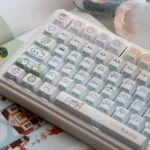 A playful Chiikawa UR82 tri-mode mechanical keyboard. Charming pastel keycaps with adorable character silhouettes are highlighted from a dynamic.