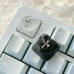 Chrome Hearts Keycap gallery highlights its gothic cross-heart design, foggy transparency, and edgy monochromatic finish.