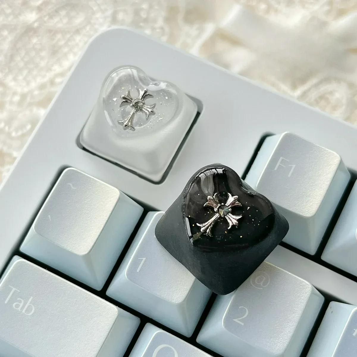Chrome Hearts Keycap gallery highlights its gothic cross-heart design, foggy transparency, and edgy monochromatic finish.