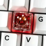 Close-up shots of the iconic Coca-Cola artisan ESC keycap, highlighting its vibrant retro branding and glossy resin finish from various angle.