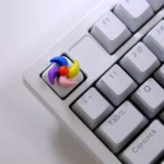 Handcrafted rotating colorful spinning windmill keycap from a unique angle, highlighting its vibrant hues, intricate miniature design, and whimsical design.
