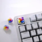 Vibrant handcrafted spinning windmill keycap showcasing colorful, rotating blades with whimsical charm, a unique artistic keyboard accent.