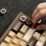 Close-up of a handcrafted artisan coffee bean keycap, showcasing real coffee beans suspended in clear resin from a unique angle.