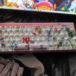 Artistic view of Demon Slayer PBT keycaps from multiple angles, highlighting vibrant side-printed characters and light-transmitting design for RGB keyboard.