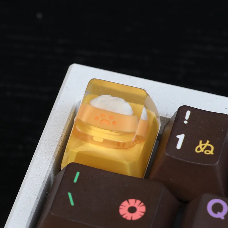 Close-up views of a charming handcrafted resin Joyful Dog Bowl Keycap, showcasing its vibrant colors and intricate miniature food bowl details.