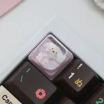 Playful close-up of a handcrafted resin artisan keycap with an adorable dog waffle and strawberry design, showcasing its glossy finish.