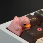 Multiple playful angles of the adorable resin duck keycap, showing its vibrant colors and inviting texture for delightful tactile stress relief.
