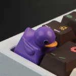 Adorable resin duck keycap, vibrant and playful, shown from multiple angles. This tactile stress relief keycap adds charming style to any keyboard.