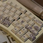 A collection of artisan embroidered PBT keycaps set, Cherry profile, Alice layout, displayed from various angles, revealing intricate textile art and vibrant design.