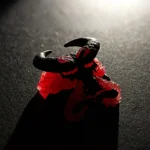 Close-up of a backlit artisan resin keycap, showcasing its dynamic molten red flame and collapsing beast design, an artistic blend of power.