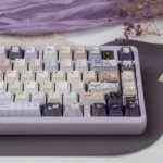 Dreamy Pearlescent Floral PBT Dye-Sub Keycap Set, artfully displayed from a unique angle, highlighting intricate delicate floral patterns and a soft hues.