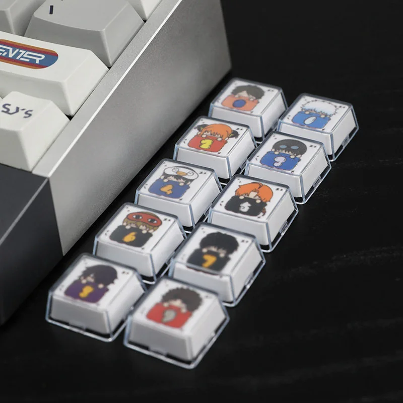 Close-up of the whimsical Gintama sleeping artisan resin 10-keycap set, showcasing glossy finish, vibrant details, and playful characters from various angles.