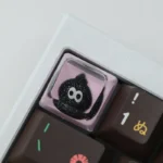 Artistic shots of a whimsical handcrafted resin artisan keycap, showcasing its unique glitter ink drop design and sparkling fluid depths from multiple angles.