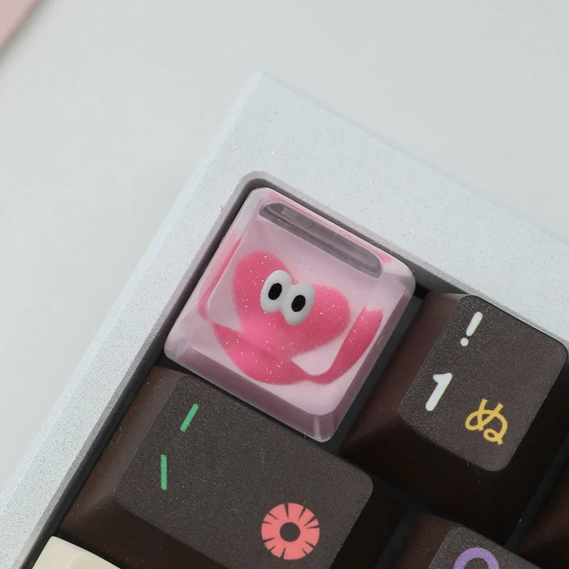 Close-up of a whimsical Glitter Pink Heart Keycap, handcrafted from sparkling resin, showcasing its charming pink heart design for a personalized keycaps.