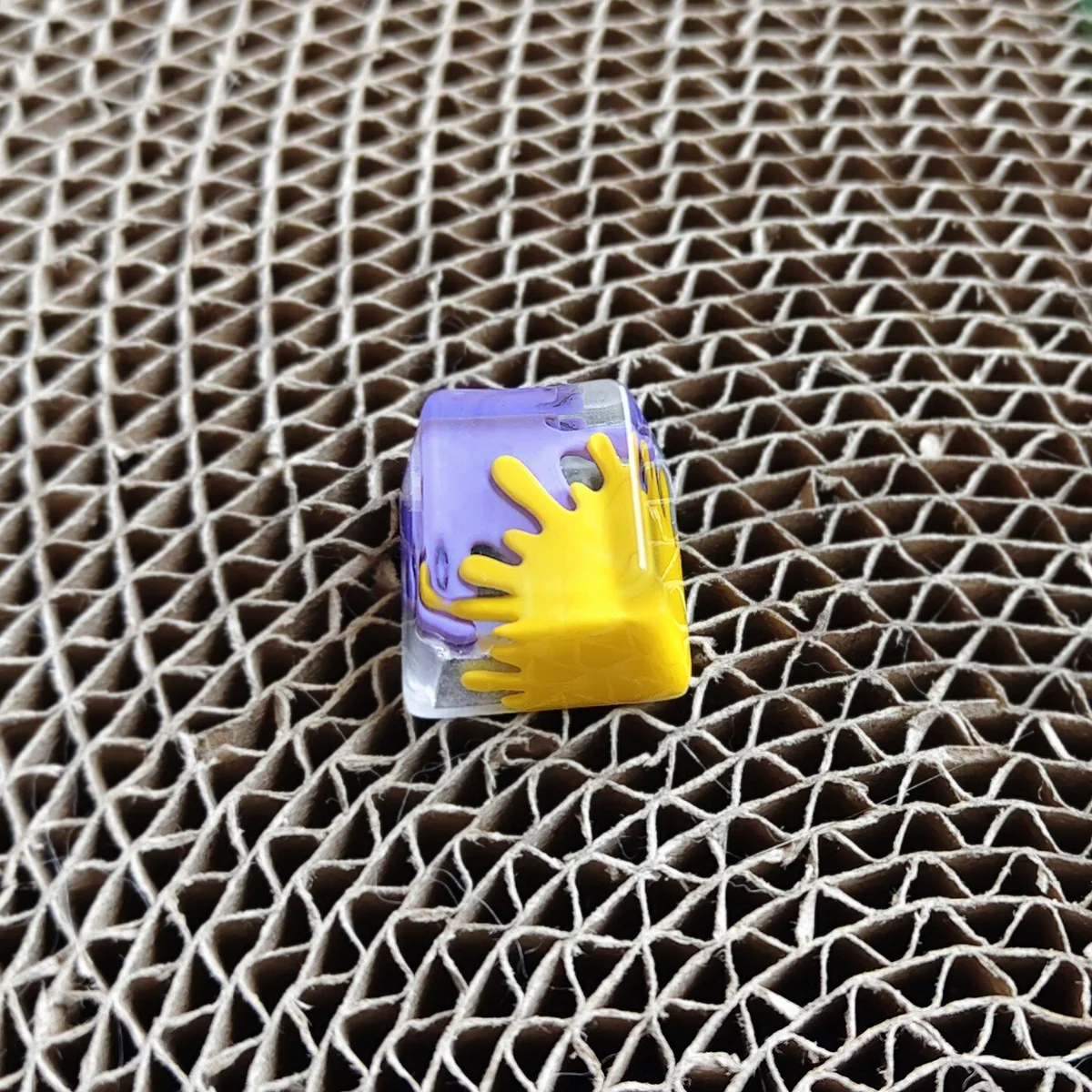 Close-up of a vibrant handcrafted graffiti resin ESC keycap, showcasing its unique abstract splatter art and bold, contrasting colors from an upward angle.
