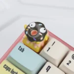 Close-up of a handcrafted 3D chocolate donut keycap, showcasing its realistic texture and whimsical sprinkles from a unique angle.