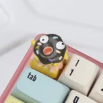 Close-up of a whimsical handcrafted 3D chocolate donut keycap, showcasing its realistic texture and vibrant sprinkles, adding charming flair.