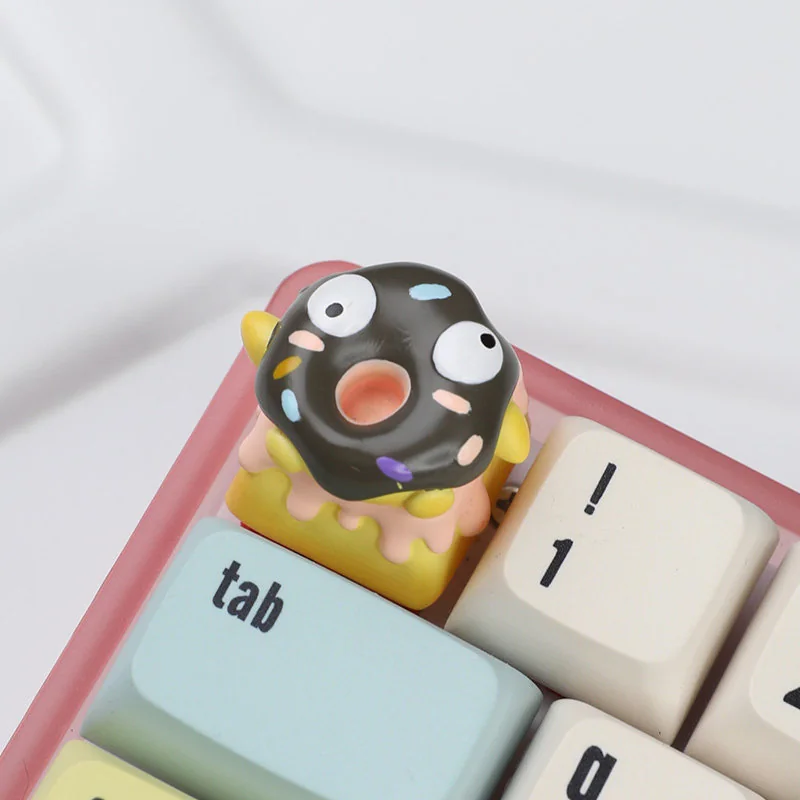 Close-up of a whimsical handcrafted 3D chocolate donut keycap, showcasing its realistic texture and vibrant sprinkles, adding charming flair.