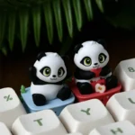 Close-up of a handcrafted resin panda keycap, showcasing its adorable, intricately detailed design and whimsical pose from various angles. An artistic angle.