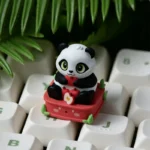Handcrafted resin panda keycap featuring a whimsical panda playfully holding a vibrant red apple, adding an adorable, nature-inspired touch to your keyboard.