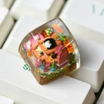 Close-up view of a whimsical handcrafted resin penguin keycap, showcasing its glossy finish and vibrant arctic colors from a unique angle, perfect for collectors.