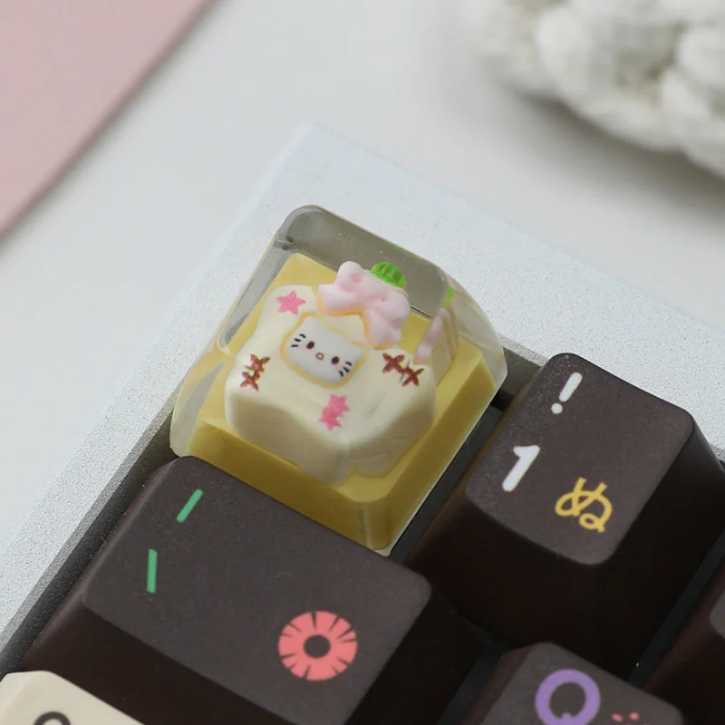 Handcrafted whimsical Hello Kitty resin artisan keycap, showcasing a delightful scene in a clear custard star bottle with sparkling details.