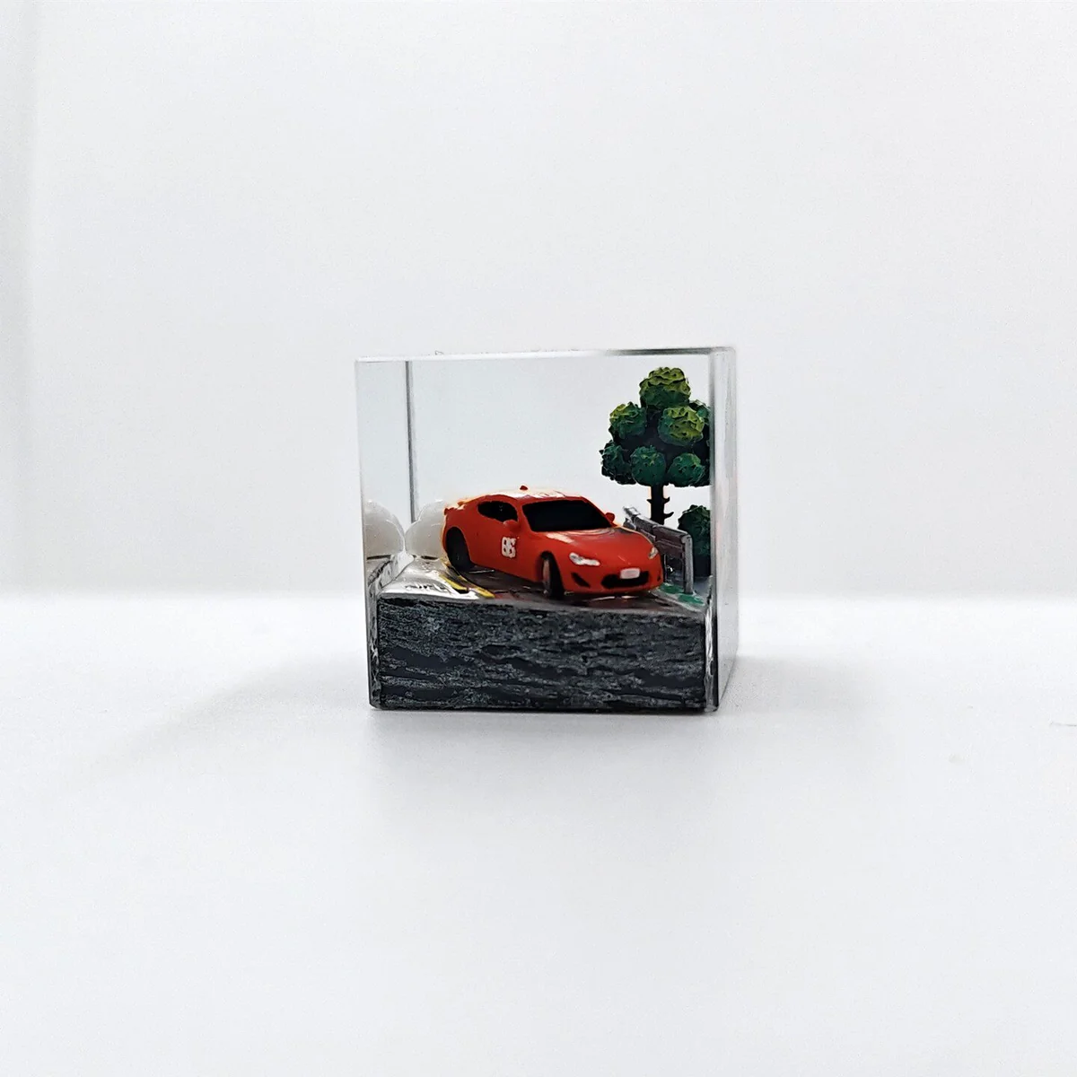 Captivating close-up of the Initial D AE86 drifting artisan JDM resin keycap, revealing intricate details of the miniature car mid-drift from a dynamic design.