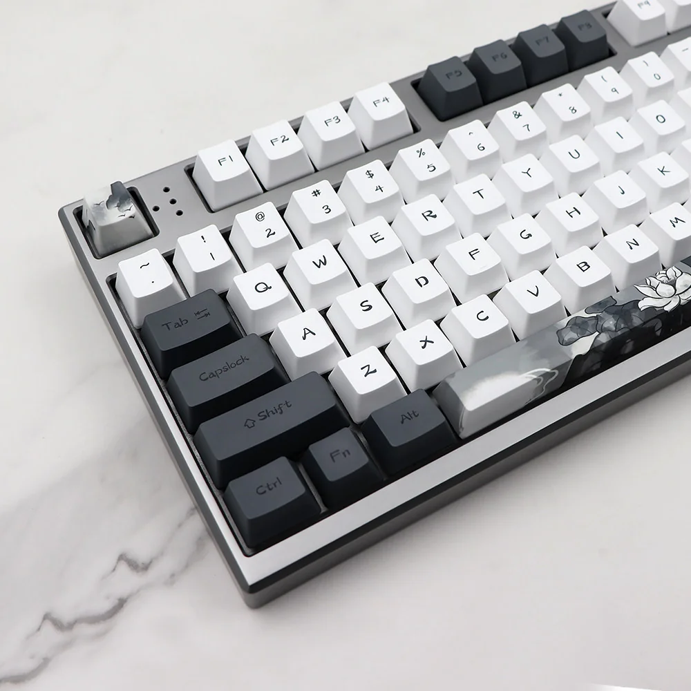 An angled shot of the Serene Lotus PBT Dye-sub Keycap Set, showcasing the tranquil PBT keycaps and their elegant, subtle lotus flower artistic design.