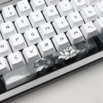 Angled view of the Serene Lotus PBT Keycap Set, showcasing tranquil PBT and elegant dye-sub lotus designs. This artistic perspective highlighting serene design.