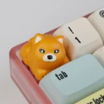 Adorable 3D Shiba Inu resin artisan keycap, handcrafted with vibrant detail. Playfully shown from an expressive angle, highlighting its charming feature.