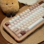 Angled shot of the Caramel Maillard keycap set, displaying its durable PBT dye-sublimated caramel hues with creamy accents in Cherry profile.