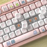 A collection of Strange Beast MOA PBT keycaps from various angles, showcasing their whimsical monster art and uniform ergonomic profile for comfortable.