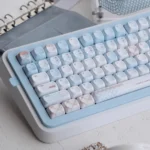 Close-up of the unique Cocoa Blue PBT dye-sub keycap set, displaying its warm cocoa and serene blue palette from various angles for a premium desktop.