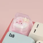 A close-up view of the adorable handcrafted piggy donut artisan ESC keycap, showcasing its whimsical dessert design from multiple angles.