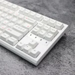 Pink Bear PBT Keycaps Set. A whimsical angle shows white keycaps with charming pink bear designs. Highlights premium quality and wide compatibility.