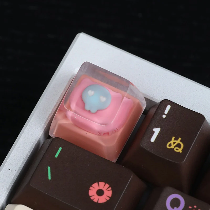 Multiple charming views of the whimsical handcrafted resin pink cat keycap, highlighting its adorable design and luminous details from various angles.